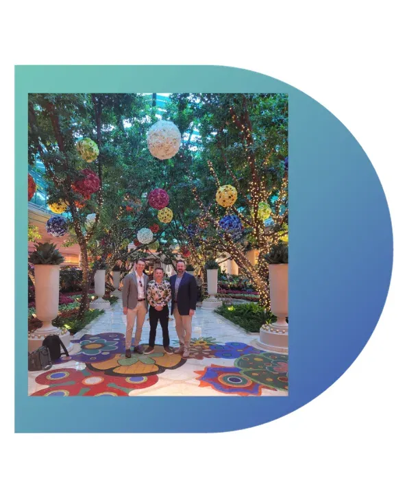 Three Lavanda team members standing beneath a colourful garden display in Las Vegas.