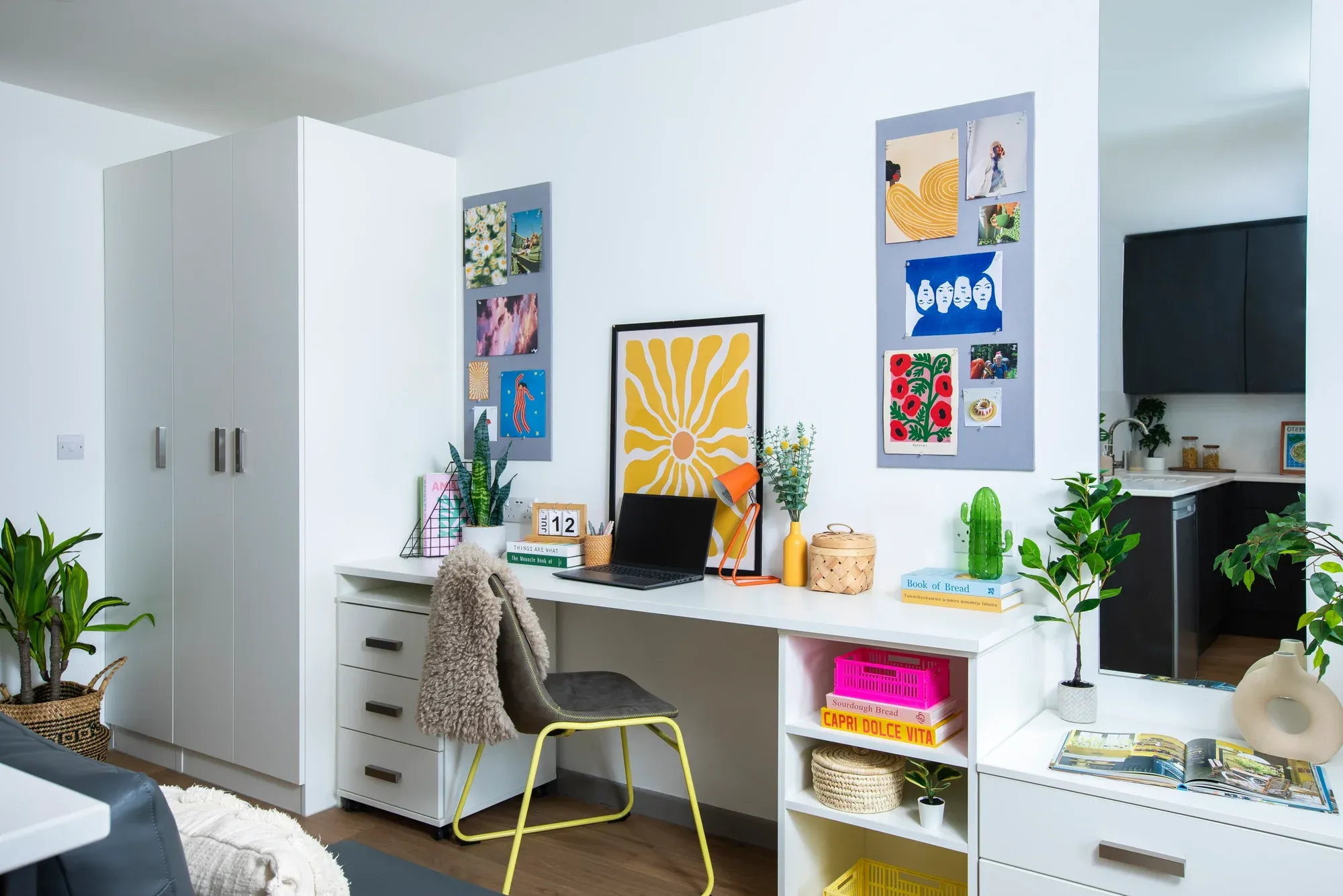 A student study bedroom with a desk, posters and storage.