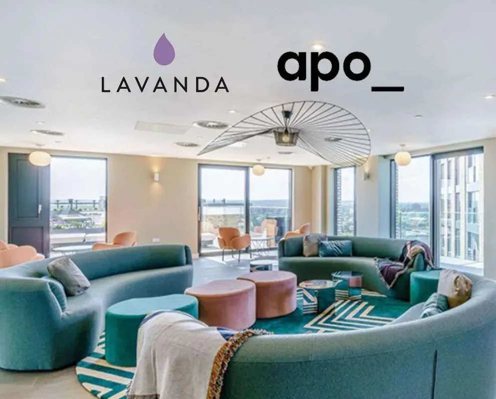 A curved teal sofa and patterned rug in a top-floor resident lounge with floor-to-ceiling windows, beneath the Lavanda and apo logos.