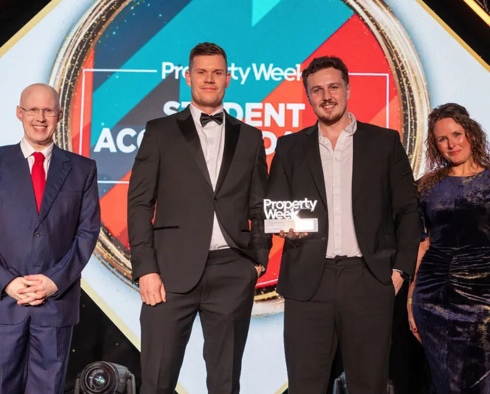 Four people in evening dress on stage in front of the Property Week Student Accommodation Awards backdrop.